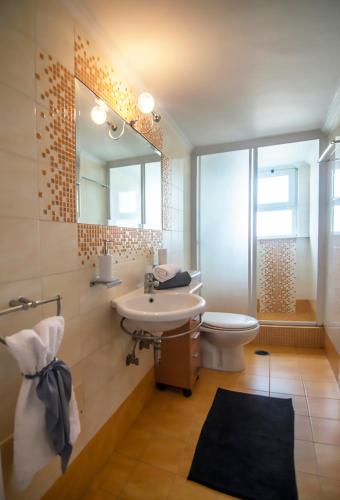 a bathroom with a sink and a toilet and a mirror at Akrata's Elegant Luxury Suite in Akrata
