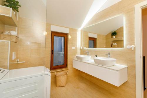 a bathroom with two sinks and a large mirror at Vila Rušinac - private heated pool in Kaštela