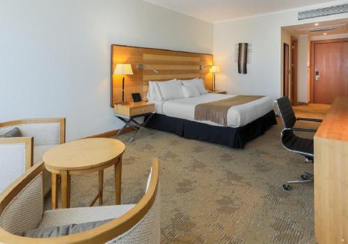 a hotel room with a bed and a desk and a table at Sonesta Hotel Osorno in Osorno