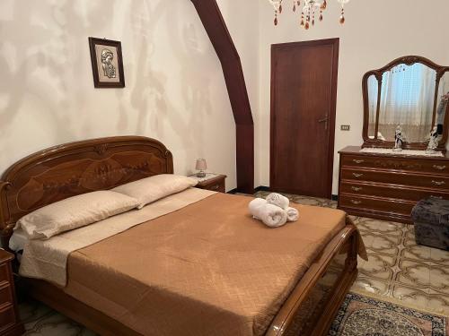 a bedroom with a bed with a teddy bear on it at Casa vacanza Giovannella in Custonaci