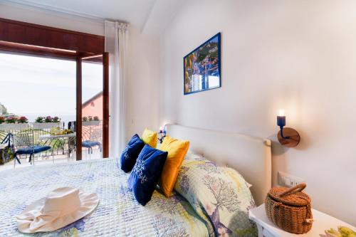 a bedroom with a bed with blue and yellow pillows at Sofì Sorrento Suites in Sorrento