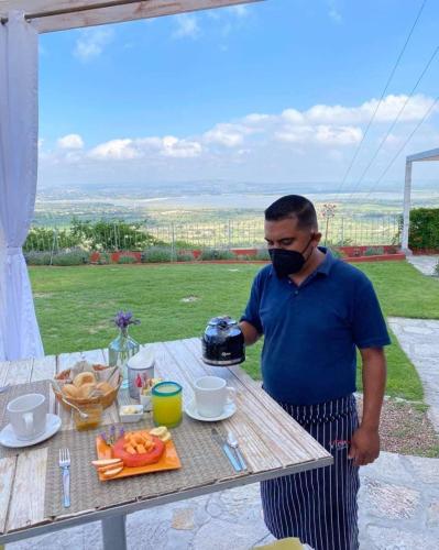 a man wearing a mask standing next to a table at View Hotel Boutique in San Miguel de Allende