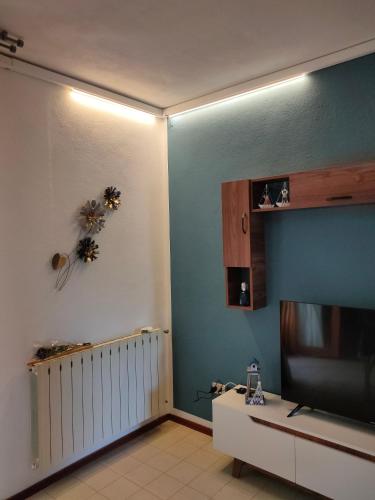 een woonkamer met een flatscreen-tv aan de muur bij Casa Polly in Follonica
