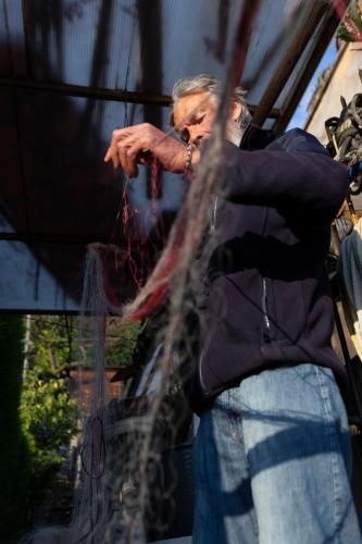 an older man standing in front of a window at La Foresta Monteisola in Monte Isola