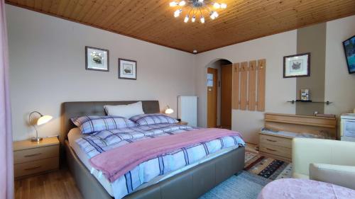 um quarto com uma cama grande e um tecto de madeira em Ferienparadies Gutounik em Pörtschach am Wörthersee