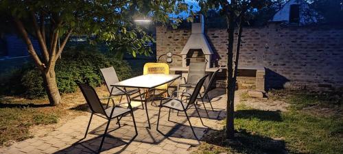 a table and chairs in a backyard with a stove at Apartments Osijek by the River in Osijek