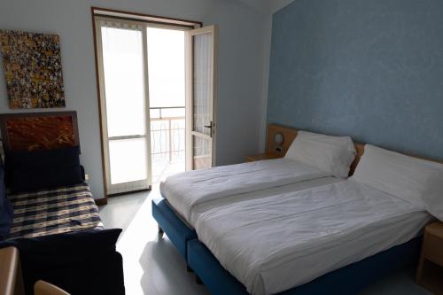 a bedroom with a bed and a large window at La Foresta Monteisola in Monte Isola