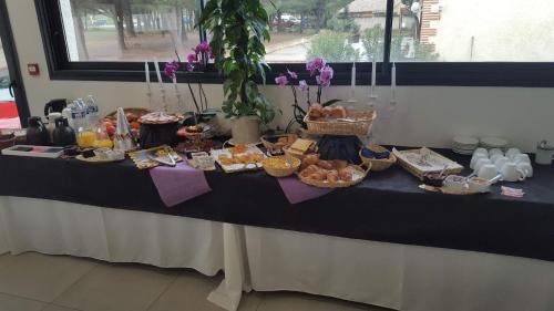 ein Tisch mit einem Buffet mit Speisen darauf in der Unterkunft Hôtel Restaurant Mas del Gall in Castelnou