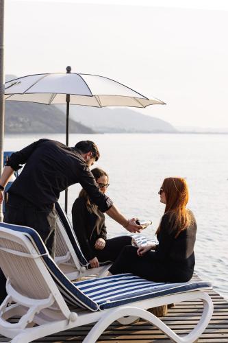 a group of people sitting on a boat on the water at La Foresta Monteisola in Monte Isola