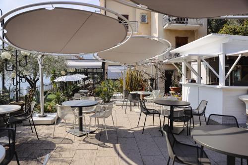an outdoor patio with tables and chairs and umbrellas at La Foresta Monteisola in Monte Isola