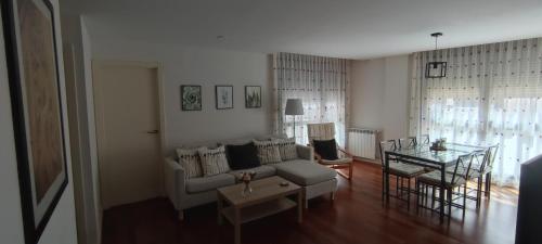 sala de estar con sofá y mesa en Apartamento Sabiñanigo Las Margas Pirineos, golf y piscina en Sabiñánigo