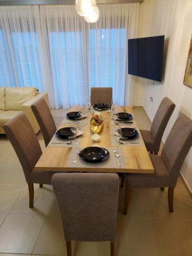 a wooden table with chairs and a dining room at Luxury Rhodian Panorama in Ixia