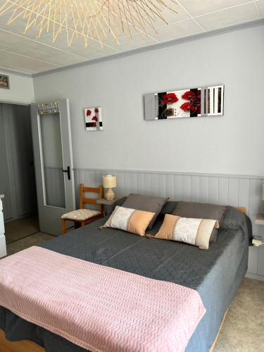 1 Schlafzimmer mit 2 Betten und einem TV an der Wand in der Unterkunft Aux hameaux des thermes in Bagnoles de l'Orne