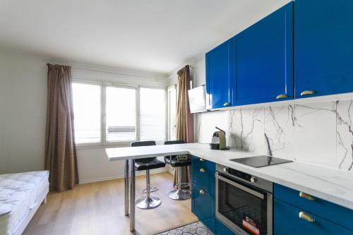 eine Küche mit blauen Schränken und einer Arbeitsplatte in der Unterkunft Bright Studio Of 29m With Wifi Near Paris in Issy-les-Moulineaux