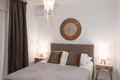 a bedroom with a bed and a mirror on the wall at G&J Deluxe Apt II in Zakynthos Town