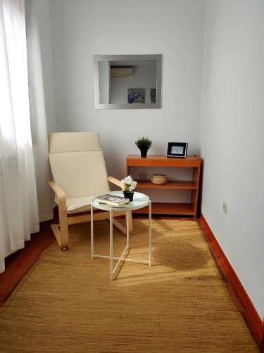 a living room with a table and a chair at Casa Maria in Olivenza