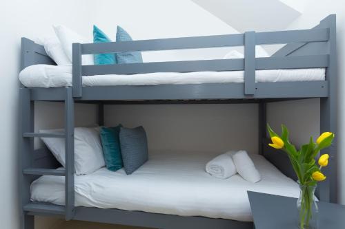 een stapelbed met witte kussens en een bureau bij Little Gem in St Ives