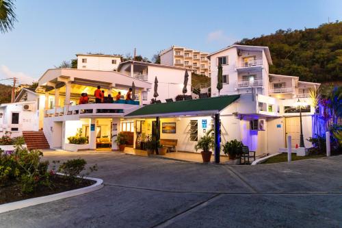 a large white building with people on the balcony at Siesta Hotel in Morne Rouge