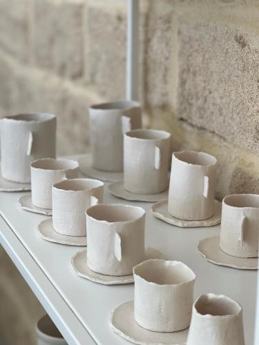 a white table with white cups and saucers at CinziaHome Boutique B&B Spiaggia Privata in Lido di Fermo