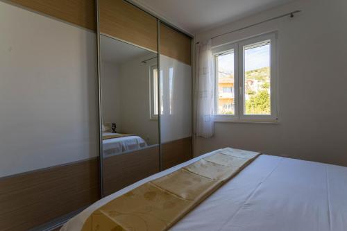 ŽrnovnicaにあるApartman MARELのベッドと大きな鏡のある寝室