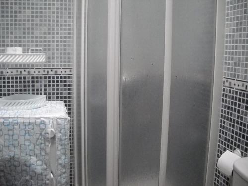 eine Dusche im Bad mit weißen Fliesen in der Unterkunft Casa Emilia in Almería