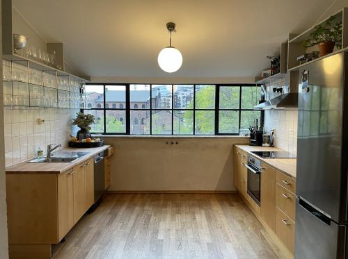 a kitchen with a sink and a large window at The Urban Penthouse in Oslo