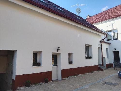 uma casa branca com uma fachada vermelha e branca em Ubytování u Mráků em Moravská Nová Ves
