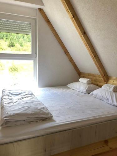 a bed in a room with a window at Guest House Tamara in Žabljak