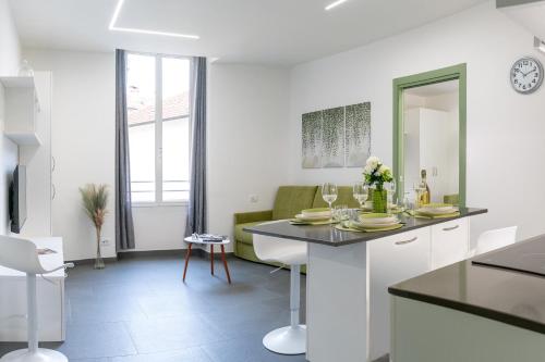 a kitchen and living room with a table and chairs at Colours Apartments & Rooms in Sanremo