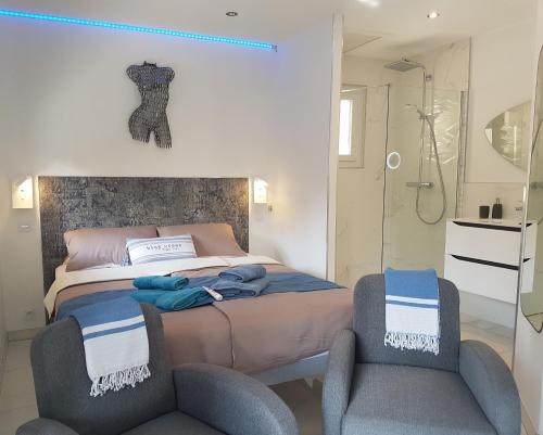 1 dormitorio con 1 cama y 2 sillas en Villa Calma Port Venus Village Naturiste Piscine & vélo, en Cap d'Agde
