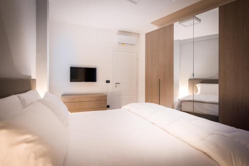 a bedroom with a white bed and a television at TURINHOMETOWN Residence Apartments in Turin