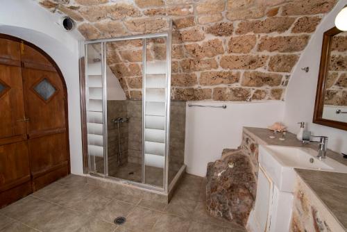 a bathroom with a glass shower and a sink at Goulas Traditional Guesthouse in Monemvasia