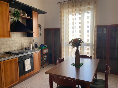 a kitchen with a table with a vase of flowers on it at NoiSalento in Marina di Mancaversa
