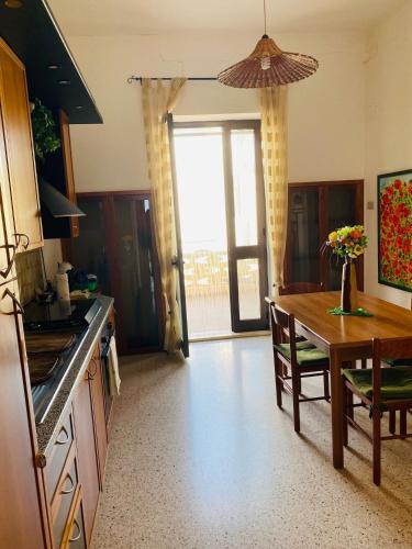 a kitchen with a table and a dining room at NoiSalento in Marina di Mancaversa