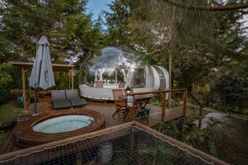 a backyard with a hot tub and a iguana at BubbleSky Glamping 40 min from Medellin in El Retiro