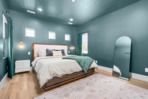 a blue bedroom with a bed and a mirror at New Mountain Retreat with Hot Tub & Putting Green in Heber City