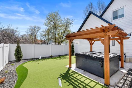 a wooden pergola on a lawn in a backyard at New Mountain Retreat with Hot Tub & Putting Green in Heber City