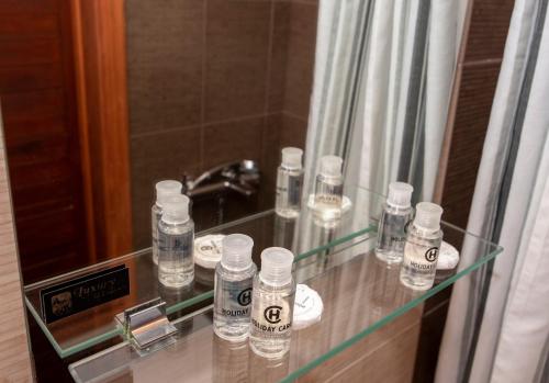 a glass counter with water bottles on it in front of a mirror at Goulas Traditional Guesthouse in Monemvasia