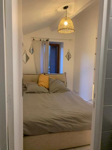 a bedroom with a bed and a pendant light at TinyHouse in La Roquette-sur-Siagne