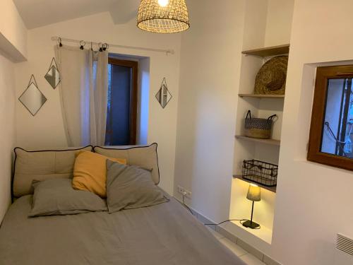 a bedroom with a bed with a yellow pillow at TinyHouse in La Roquette-sur-Siagne