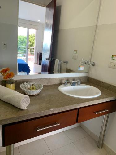 a bathroom with a sink and a large mirror at Hotel Sol de Piedemonte in Yopal