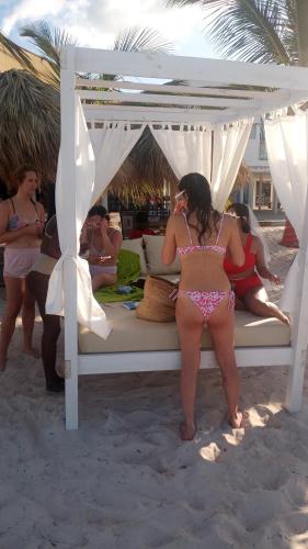 a woman in a bikini sitting on a bed on the beach at Rolando share apart in Punta Cana