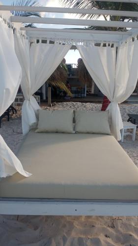 Cama en la playa con dosel blanco en Rolando share apart en Punta Cana