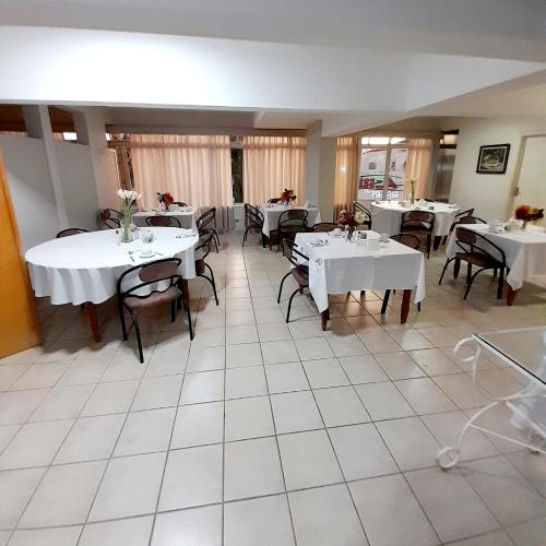 a dining room with white tables and chairs at Jales Center Hotel in Jales