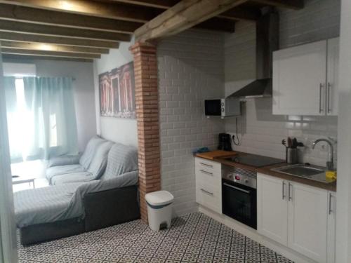 kuchnia z kanapą w niewielkim pokoju w obiekcie Casa Rural La Plata w mieście Aljucén