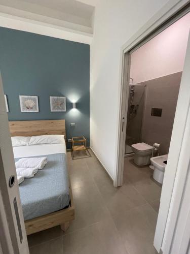 ein Schlafzimmer mit einem Bett und ein Badezimmer mit einem WC in der Unterkunft Le Casuzze di Siculiana in Siculiana