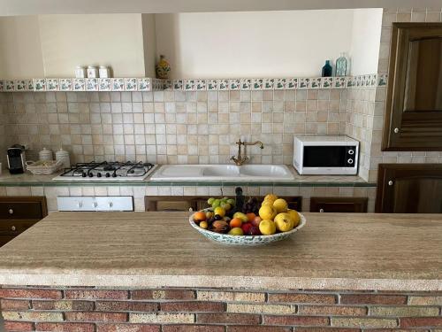 a bowl of fruit on a counter in a kitchen at Villa Mancosta in Marinella di Selinunte
