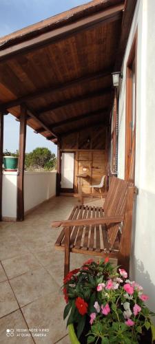a wooden bench sitting on a porch with flowers at Il Cigno Affittacamere Bed & Breakfast in Ponza