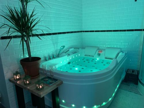 a blue bath tub with lights in a bathroom at Duo Romantic in Bagnères-de-Bigorre