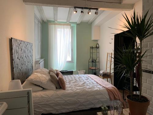 a bedroom with a bed and a window at Duo Romantic in Bagnères-de-Bigorre